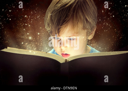 Little boy and the old magic book Stock Photo