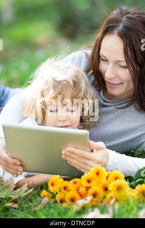 Family using tablet PC outdoors Stock Photo