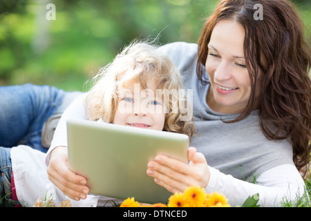 Family using tablet PC outdoors Stock Photo