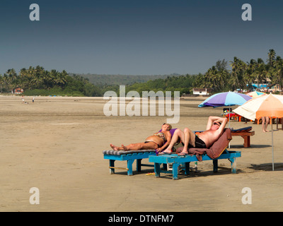 India, Goa, Mandrem beach, tourists sunbathing on sunloungers Stock Photo