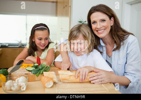 Mother making sandwiches with her children Stock Photo