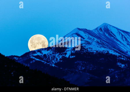 Full moon setting over Rocky Mountains, Salida, Colorado, USA Stock Photo