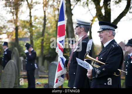 Police offers stand by the grave of PC James Gordon, a young officer who was murdered on duty in 1893. Stock Photo