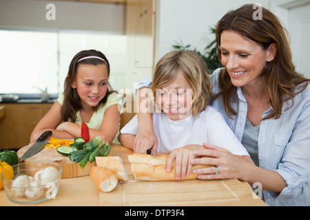 Woman making sandwiches with her children Stock Photo