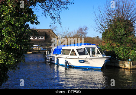 A small cruiser at private moorings on the Norfolk Broads at South Walsham, Norfolk, England, United Kingdom. Stock Photo