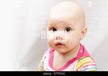 Little brown eyed Caucasian baby girl closeup studio portrait Stock Photo