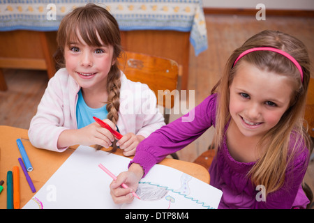 Cute schoolgirls drawing in a coloring book Stock Photo