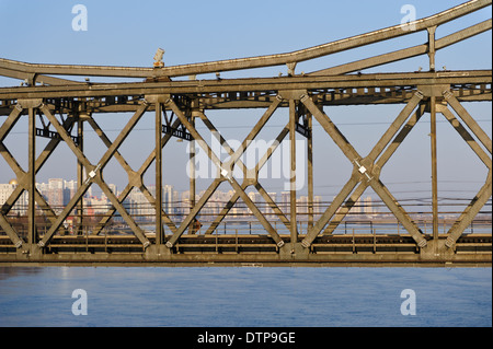 The Sino-Korean Friendship Bridge .  High rise buildings of Dandong city at background Liaoning province. Dandong, China. Stock Photo