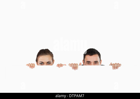 Business partners hiding behind a sign Stock Photo