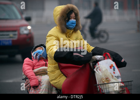 Mother and daughter wear masks in Beijing, one of the most air polluted cities in the world. 22-Feb-2013 Stock Photo