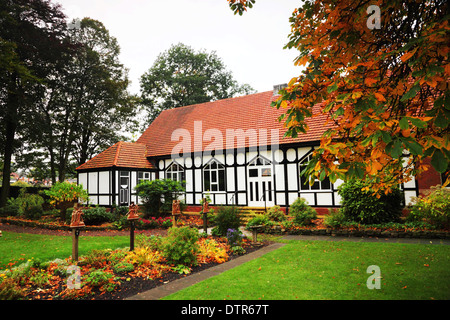 A mock-Tudor half-timbered church with a red tile roof in autumn. Stock Photo