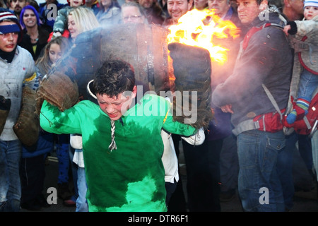 A boy carries a flaming tar barrel on his shoulders. Stock Photo