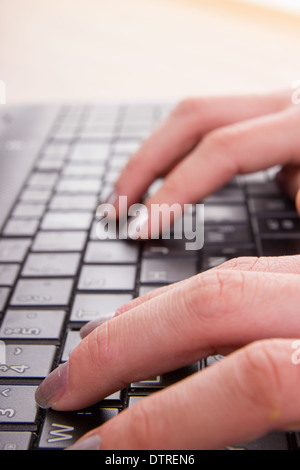 hands of business woman typing on laptop keyboard with nail polish Stock Photo