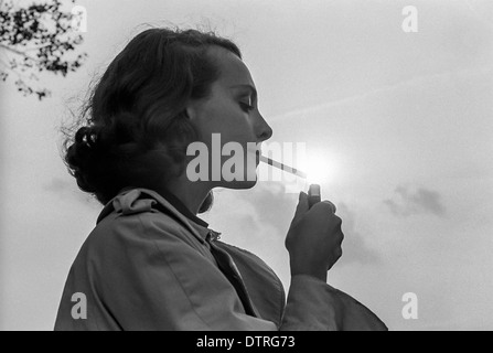 Young woman lighting a cigarette Stock Photo