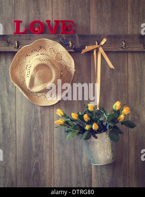 Roses with straw hat and love letters on rustic door Stock Photo