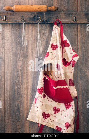 Apron hanging on hook in kitchen with utensils - vintage tone effect Stock Photo