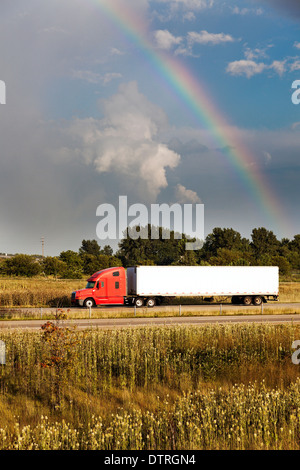 Semi truck driving under the rainbow - seen in Illinois. Stock Photo
