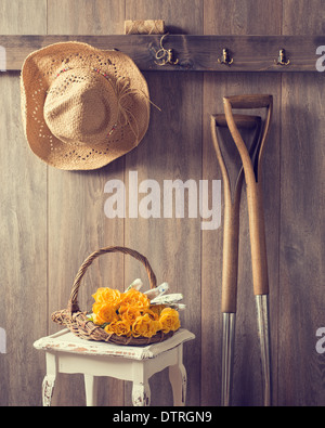Rustic country shed interior with freshly picked yellow roses in basket Stock Photo