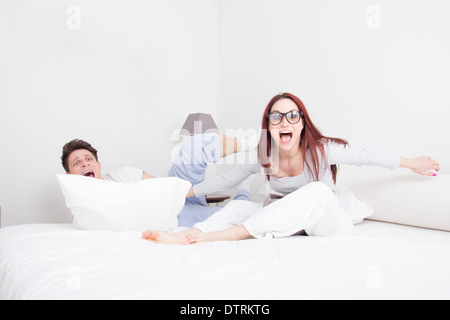 young couple in pillow fight with fanny face expression Stock Photo