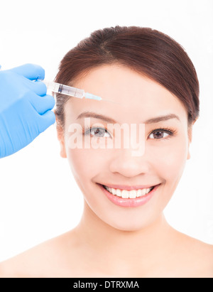 Beautiful woman gets injection in her face over white Stock Photo