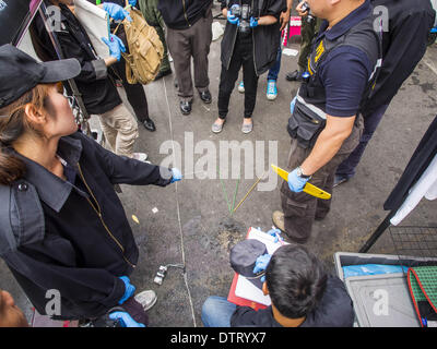 Bangkok, Thailand. 24th Feb, 2014. Thai police investigate the scene of a grenade attack that took place Sunday evening in the Ratchaprasong district in Bangkok. At least four people, three of them children, were killed in political violence over the weekend in Thailand. One in Trat province, near the Cambodian border, and three in Bangkok, at the Ratchaprasong protest site.  blast, died overnight in a Bangkok hospital. Credit:  ZUMA Press, Inc./Alamy Live News Stock Photo