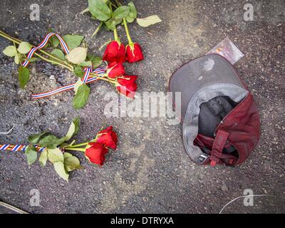 Bangkok, Thailand. 24th Feb, 2014. Roses left by mourners on the ground next to a bloody hat worn by the victim of a grenade attack on anti-government protestors at the Ratchaprasong intersection in Bangkok. At least four people, three of them children, were killed in political violence over the weekend in Thailand. Credit:  ZUMA Press, Inc./Alamy Live News Stock Photo