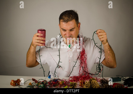 Guy struggling with a mess of party decoration Stock Photo