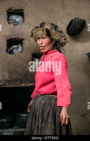 portrait of a wife / woman in her house in the andes - pink colorful jumper and worn hat Stock Photo