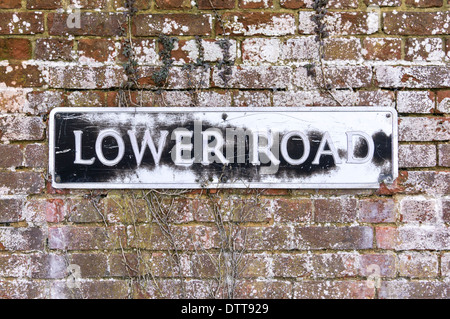 Old faded and worn street sign on brick wall UK Stock Photo