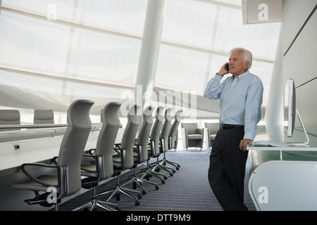 Caucasian businessman on cell phone in conference room Stock Photo