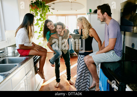 Friends relaxing together in kitchen Stock Photo