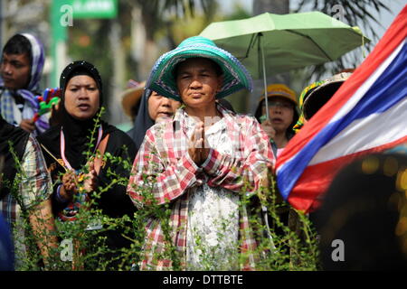 Bangkok, Thailand. 24th Feb, 2014. An anti-government protester prays at the front gate of a building owned by Thailand's Voice TV Corp during a rally in Bangkok, Thailand, Feb. 24, 2014. Anti-government protesters trying to oust Yingluck Shinawatra's government on Monday rallied outside several companies considered as the businesses of Shinawatra family. Credit:  Gao Jianjun/Xinhua/Alamy Live News Stock Photo