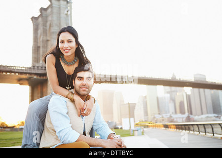 Indian couple smiling by bridge, New York, New York, United States Stock Photo