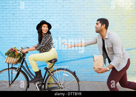 Indian man chasing girlfriend on bicycle Stock Photo