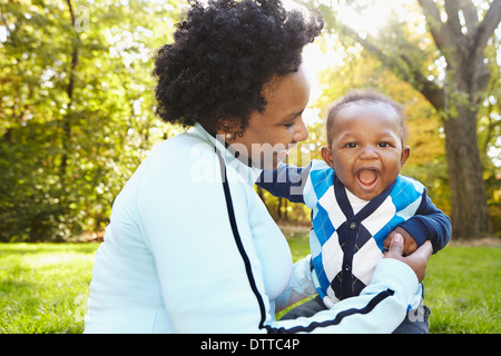 Black mother and toddler son playing in park Stock Photo