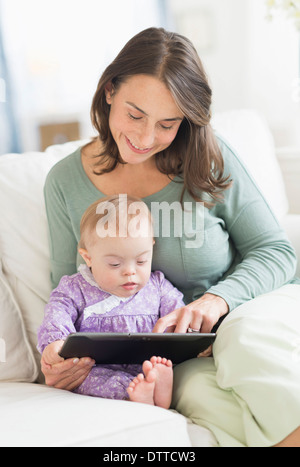 Caucasian mother reading to baby with Down Syndrome Stock Photo