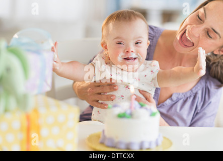Caucasian mother and baby girl with Down Syndrome celebrating birthday Stock Photo