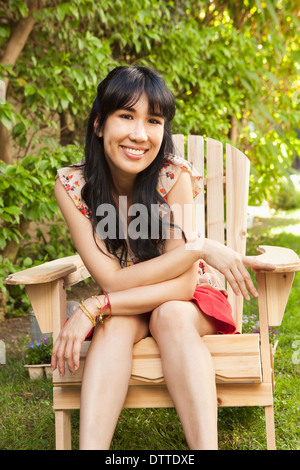 Woman sitting in chair outdoors Stock Photo