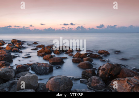 Blurred ocean washing over rocks Stock Photo