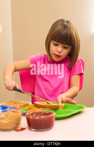 Caucasian girl making sandwich in kitchen Stock Photo
