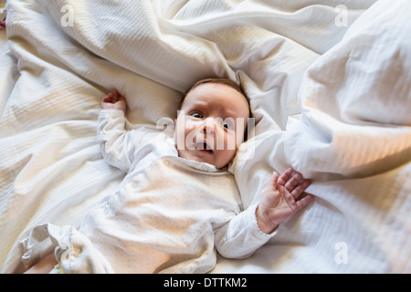 Caucasian baby gasping in bed Stock Photo