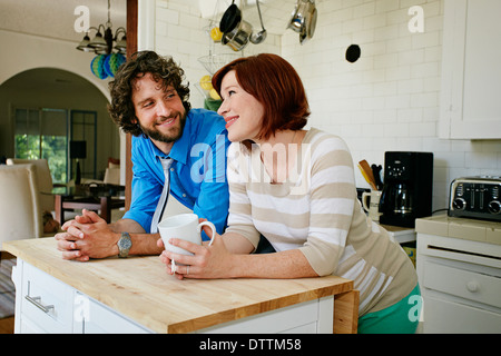 Pregnant Caucasian couple smiling in kitchen Stock Photo