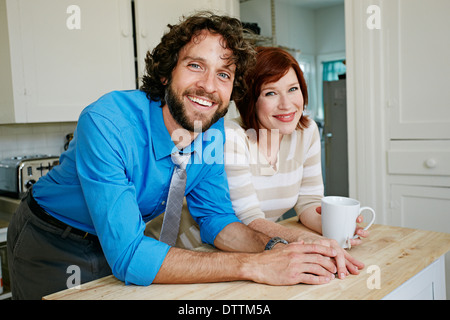 Pregnant Caucasian couple smiling in kitchen Stock Photo