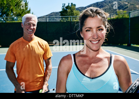 Caucasian couple standing on tennis court Stock Photo