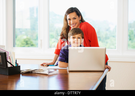Mother and son using laptop together Stock Photo