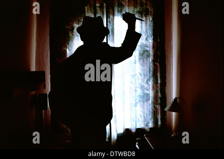 Killer's silhouette with knife in a dark room Stock Photo
