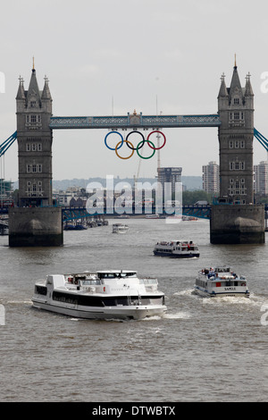 Giant set of Olympic rings are displayed from Tower Bridge on June 27, 2012 in London, England. The rings weigh over three tonnes and measure over 25 metres wide by 11.5 metres tall; they will be illuminated in a light-show every evening during the Games. Stock Photo