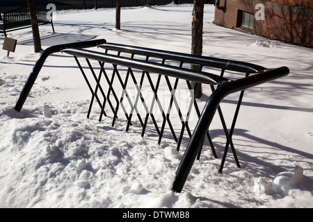 a bicycle rack sits unused in the deep winter snow in New England. Stock Photo