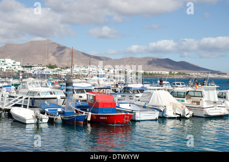 Playa Blanca Lanzarote boats in harbour with volcanoes in the background Stock Photo