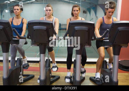 Four women working out at spinning class Stock Photo